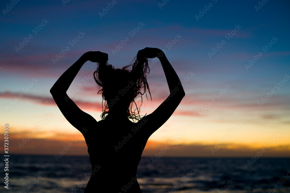 Fototapeta premium silhouette of girl at the beach at sunset