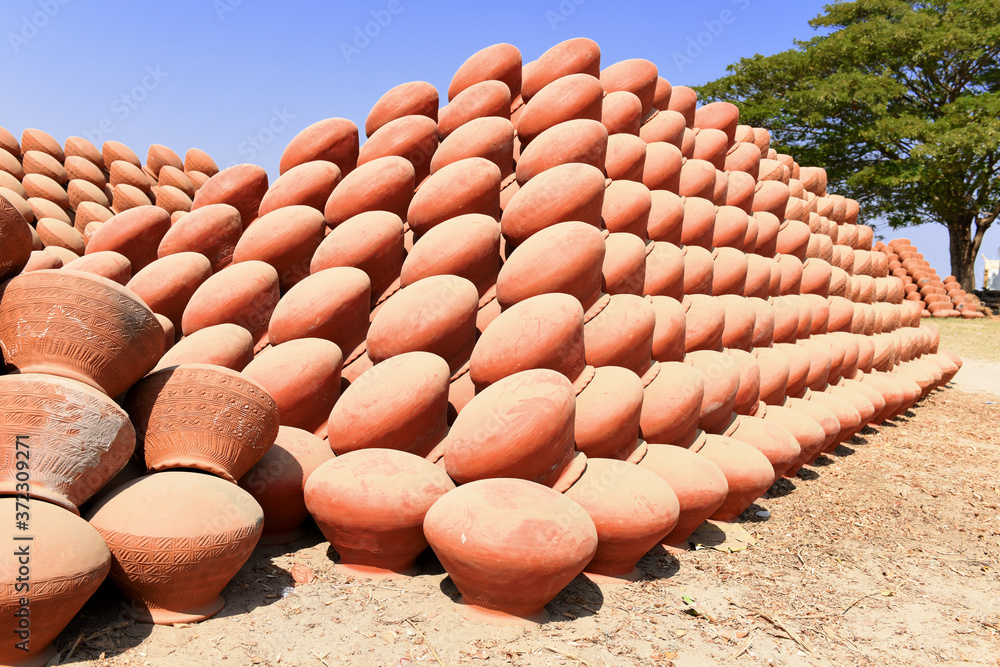 rows of handmade clay pots with decoration waiting to be fired in Mingun pottery village, Myanmar (Burma)