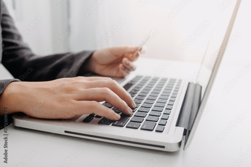 Businesswomen hands working with finances about cost and calculator and laptop with tablet, smartphone at office in morning light Businesswomen hands working with finances about cost and calculator and laptop with tablet, smartphone at office in morning light