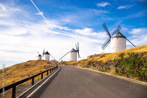 Photo of some beautiful and historical windmills located in Consuegra, Toledo, Spain during a sunny day of summer in a natural place.  photo