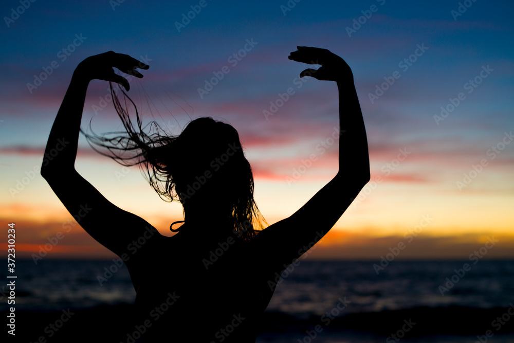 silhouette of girl at the beach at sunset