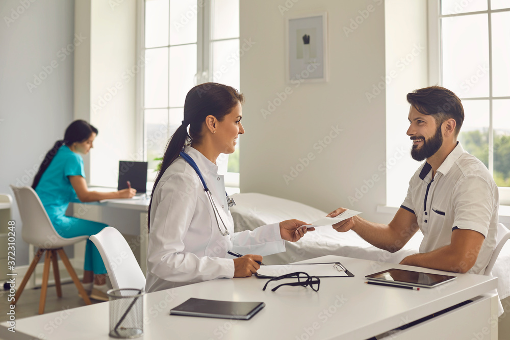 Woman doctor giving prescription to patient in clinic Woman doctor giving prescription to patient in clinic