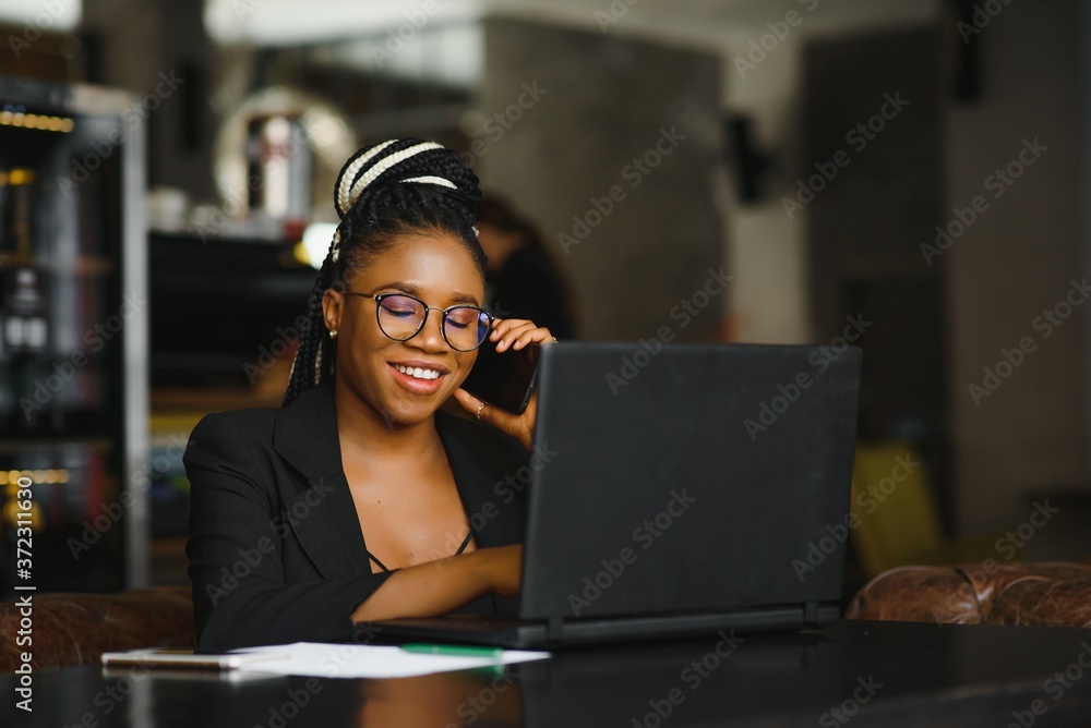 Young African American woman siting at cafe working on laptop Young African American woman siting at cafe working on laptop