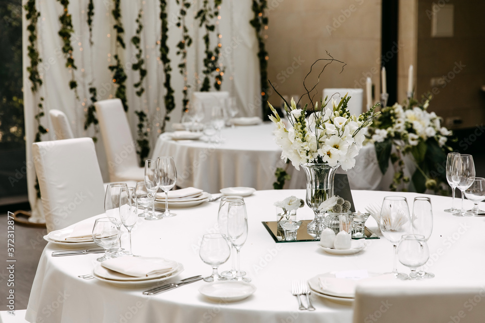 Decorated table at a restaurant. Centerpiece and tableware at a wedding party. Decorated table at a restaurant. Centerpiece and tableware at a wedding party.