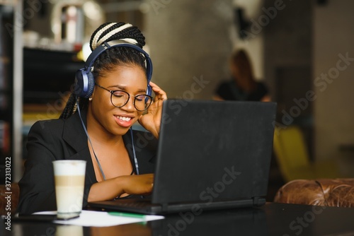 Portrait of a young black woman smiling and using laptop