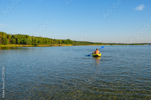 Clean lake Svityaz, Ukraine. Sandy bottom of the lake. In the distance a man in a yellow kayak. Copy space. © Ganna Zelinska