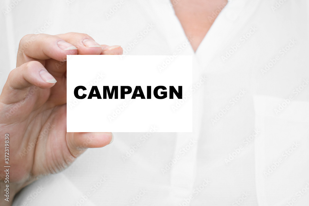 THE GIRL holds the card CAMPAIGN. Business concept THE GIRL holds the card CAMPAIGN. Business concept