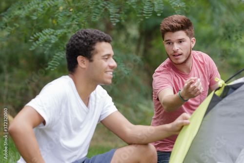 young men having misunderstanding during tent pitching