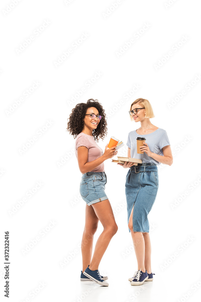 Multiethnic students with disposable cups and books on white background Multiethnic students with disposable cups and books on white background
