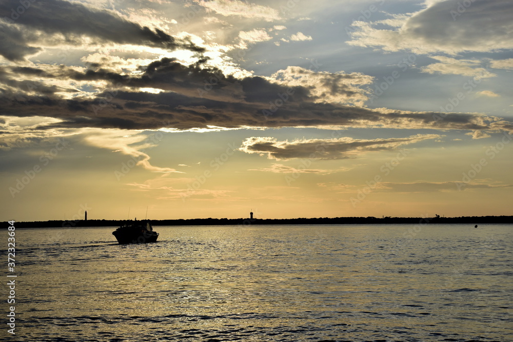In der Bucht von Arcachon fährt ein Schiff in den Sonnenuntergang