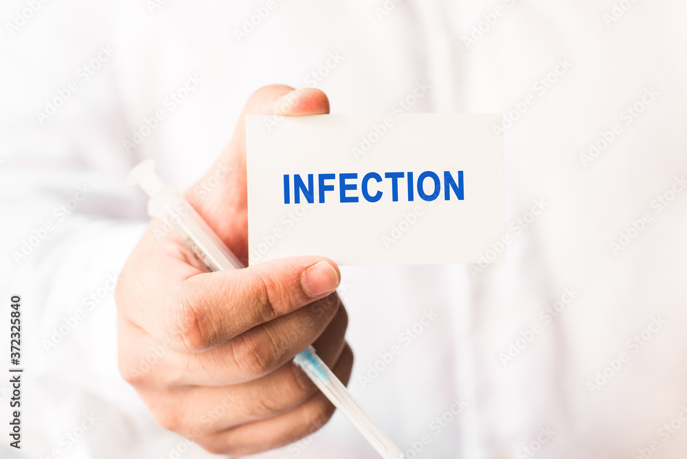 Word infection on a white background with a syringe in hand. Medicine concept Word infection on a white background with a syringe in hand. Medicine concept