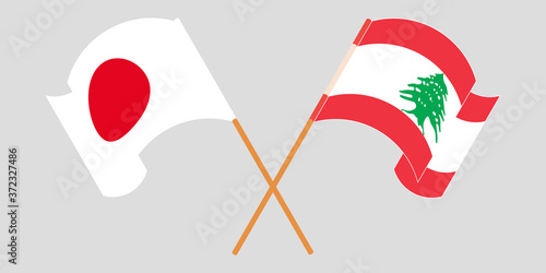 Crossed and waving flags of Lebanon and Japan