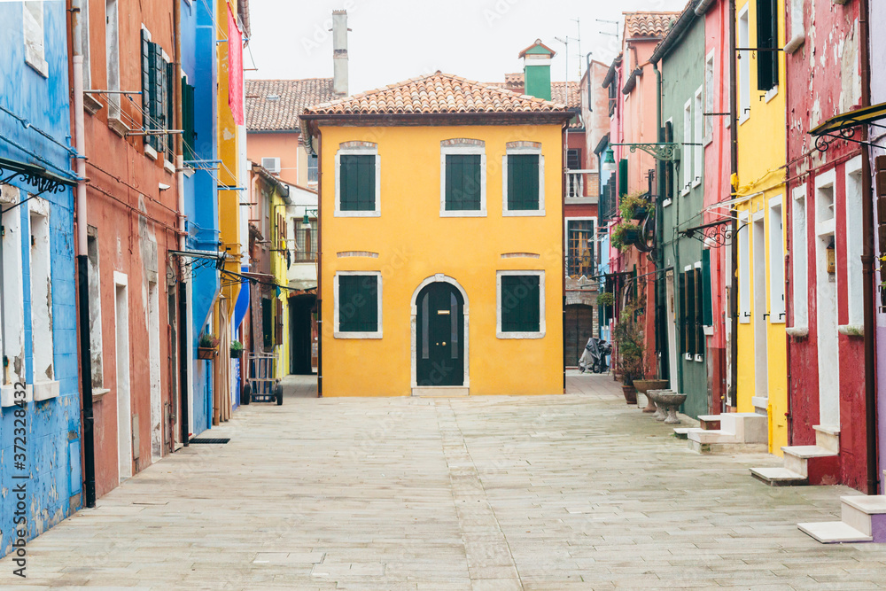 Island of Burano, Venice, Italy. Nice colored houses on a cloudy day. Singular street, tourist point, postcard of venice.