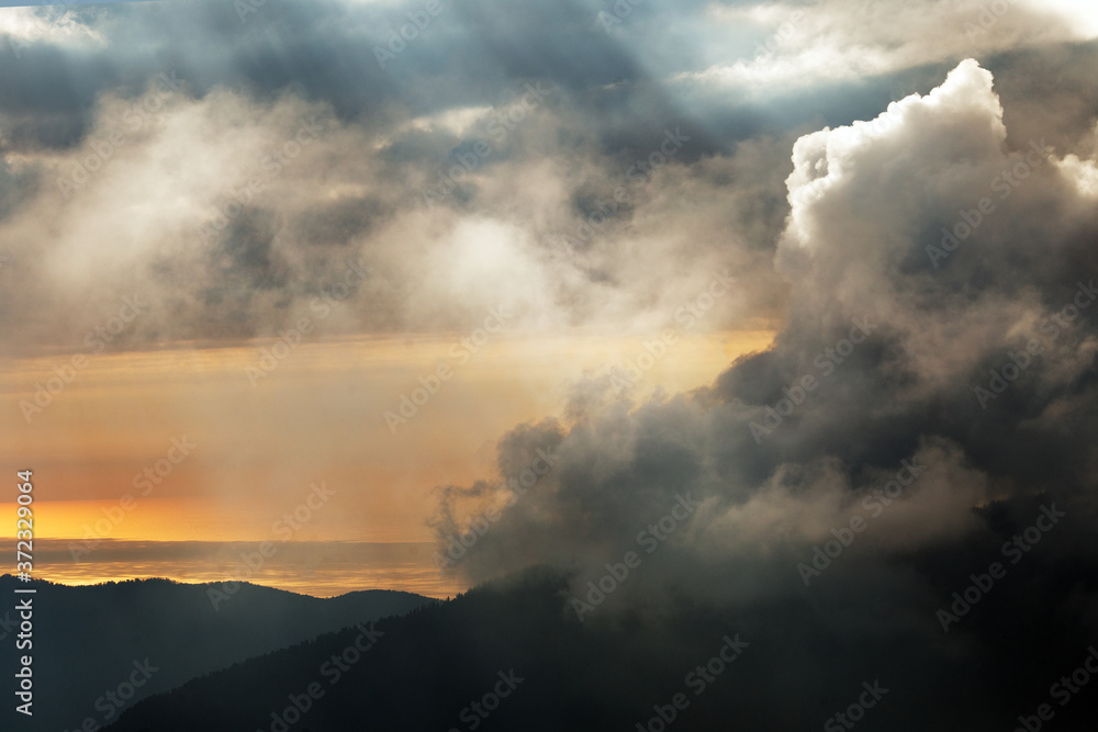 Bright and dramatic view of clouds and sun light in the mountains. Sunset