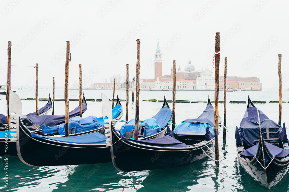 Gondolas moored by Piazza San Marco with the church of San Giorgio di Maggiore in Venice, Italy.