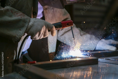 workman welds metal with welding inverter
