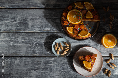 Orange cake on a gray wooden background. Hard light. Top view, copy space.