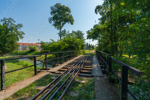 A drive across the Gasawka river for the narrow-gauge railway in the city of Żnin on a beautiful sunny day with a blue cloudless sky.