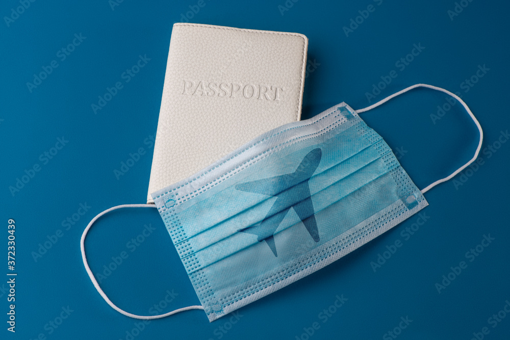 Surgical face mask with airplane print and passport on blue background Surgical face mask with airplane print and passport on blue background