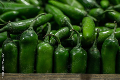 фотографія green serrano chili peppers at a market stall