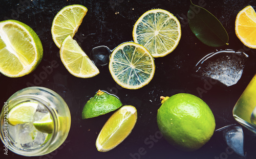 green lime Set of fresh whole and cut and slices, lime fresh water and cocktail - summer cool background