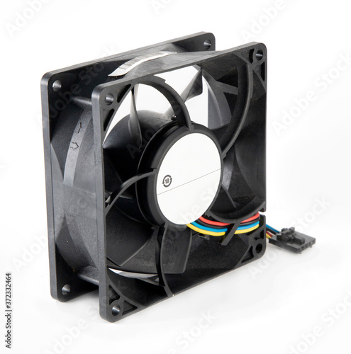 DC brushless fan with 5 volt and 12 volt DC. Mini cooling fan made of black plastic complete with cables on isolated white background.