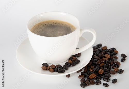 Coffee cup and coffee beans on fabric background.