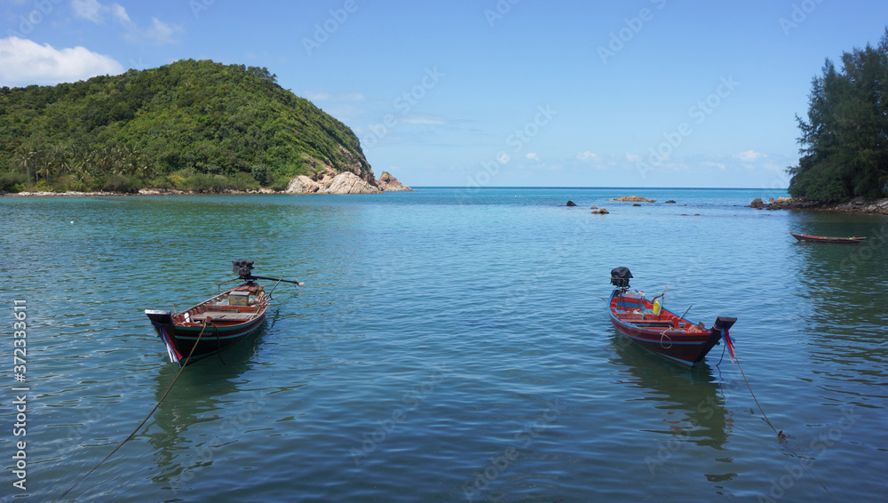 Two boats on the sea with an island on the horizon Two boats on the sea with an island on the horizon