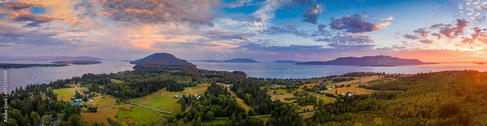 Aerial Panoramic View of a Lummi Island Sunset. Pastureland reflects a rural character to the island. Orcas Island can be seen in the background.  