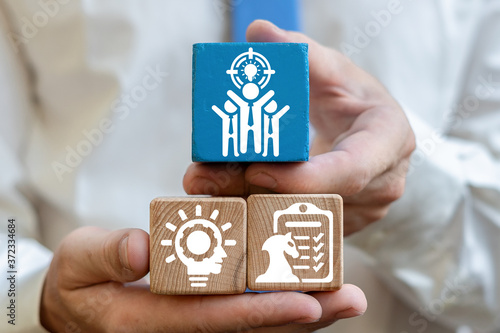 Business leadership, teamwork power and confidence concept. Businessman hands hold wooden cubes with icons.