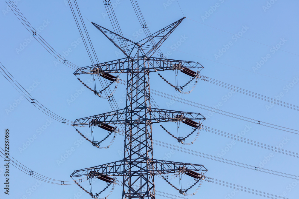 A large steel electricity transmission tower with a number of cables and terminals A large steel electricity transmission tower with a number of cables and terminals