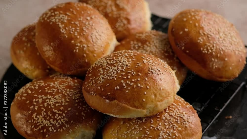 Baker woman cooking buns for burgers. Hot buns from the oven. Handmade bread Making. Preparing dough for baking buns. Preparing dough to be cook buns, bread. Beautiful background. Slow motion. Baker woman cooking buns for burgers. Hot buns from the oven. Handmade bread Making. Preparing dough for baking buns. Preparing dough to be cook buns, bread. Beautiful background. Slow motion.