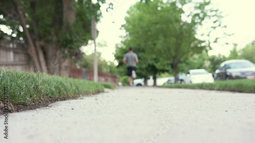 Wallpaper Mural Young caucasian man jogs on sidewalk on summer morning Torontodigital.ca