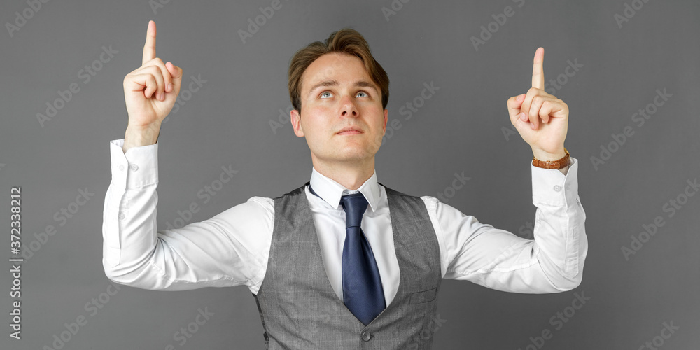 Emotional portrait of a businessman who shows his hands up. Gray background. Emotional portrait of a businessman who shows his hands up. Gray background.