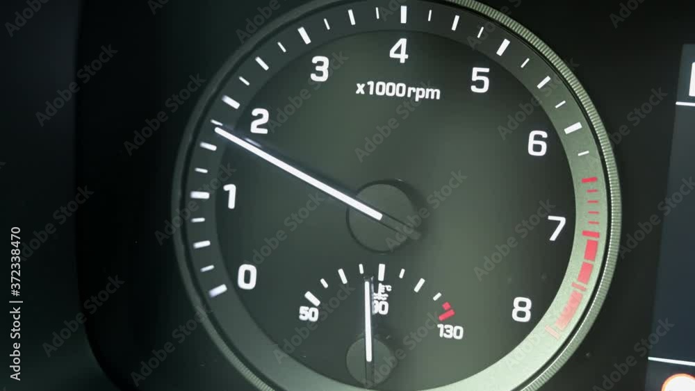 Close up of modern automotive tachometer on black background. The tachometer needle rises. Close up of modern automotive tachometer on black background. The tachometer needle rises.