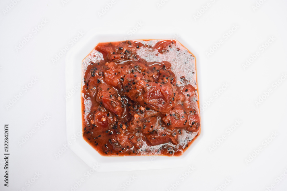 Plum chutney sweet and tangy indian chutney with little spice from tempered tadka in white background decprated with money plant and hibiscus red flower. Alu bukhare ki tasty chutney Plum chutney sweet and tangy indian chutney with little spice from tempered tadka in white background decprated with money plant and hibiscus red flower. Alu bukhare ki tasty chutney