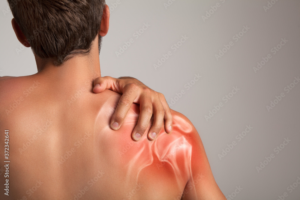 Shoulder pain, man holding a hand on a painful zone Shoulder pain, man holding a hand on a painful zone