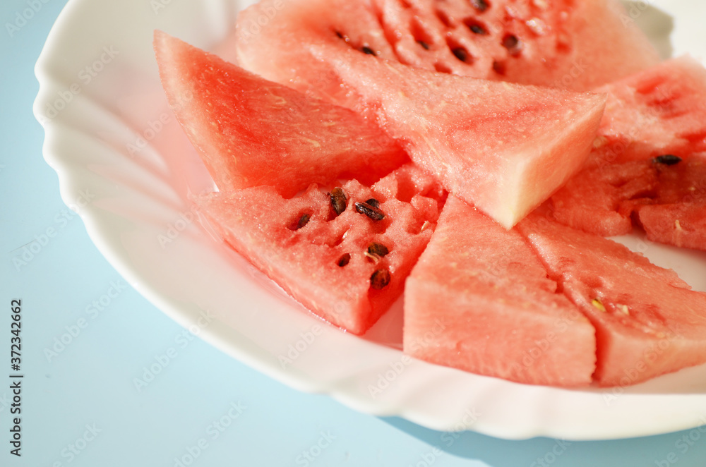 Ripe watermelon pieces on the plate isolated on blue, delicious berry Ripe watermelon pieces on the plate isolated on blue, delicious berry