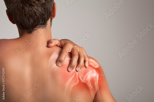 Shoulder pain  man holding a hand on a painful zone