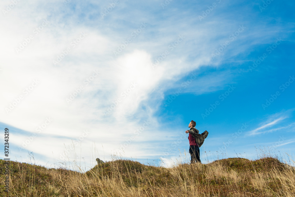 hiking mountains freedom pose by young guy lonely person on top of highland meadow travel life style poster wallpaper concept with empty copy space blue sky background hiking mountains freedom pose by young guy lonely person on top of highland meadow travel life style poster wallpaper concept with empty copy space blue sky background