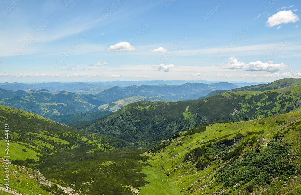 Beautiful landscape of green sunny hills and mountains. Travel concept. Carpathian mountains in summer. Beauty of nature. Hiking destination.