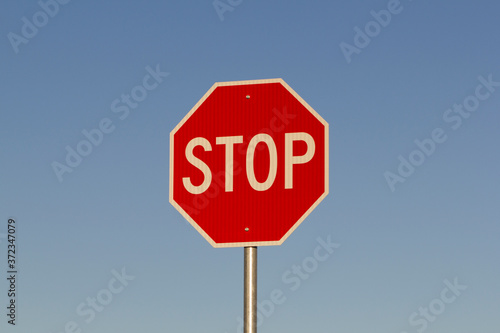 Stop sign against clear blue sky during sunrise or sunset. Business concept with copy space.