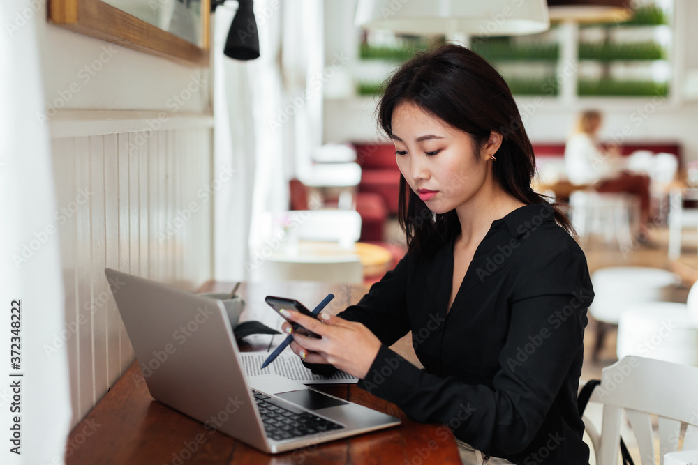 Ethnic manger using smartphone during work in cafe Ethnic manger using smartphone during work in cafe