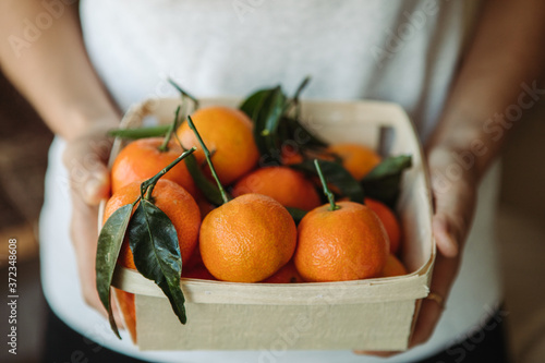 Holding a basket of tangerines