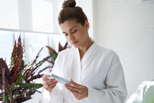 Calm lady reading the ingredients of her beauty product