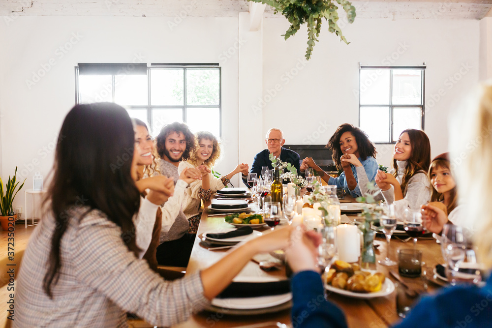 Diverse family praying at table Diverse family praying at table