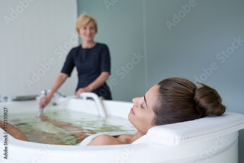 Young woman enjoying hydromassage in whirlpool bath photo