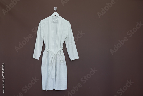 New white bathrobe isolated on brown background