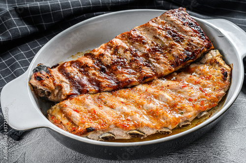 Rack of pork spare ribs  in hot and barbecue sauce. Gray background. Top view