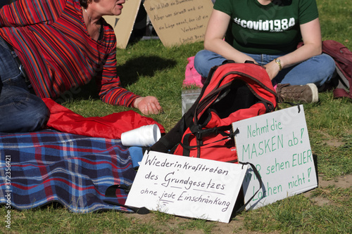 Sitzende Teilnehmer mit Plakaten an einer Corona-Demonstration gegen Maskenpflicht in Deutschland photo